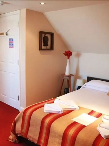 Gemütliches Hotelzimmer mit Tagesdecke und Kunst an der Wand