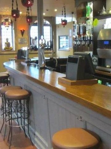 Barbereich mit Holztheke und stilvollen Hockern