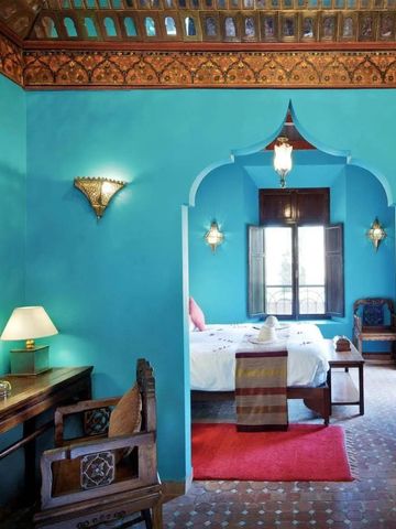 Farbenfrohes Schlafzimmer mit dekorativem Bogen und traditionellen marokkanischen Elementen