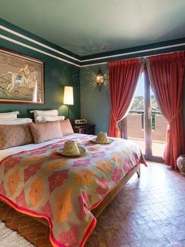 Gemütliches Doppelzimmer in warmen Farben mit Balkon und roten Vorhängen