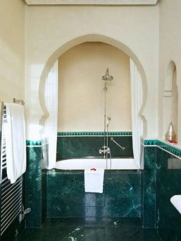Orientalisch gestaltetes Badezimmer mit grünen Fliesen und eleganter Badewanne