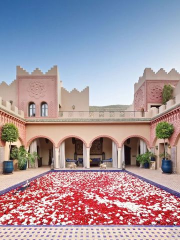 Prachtvoller Innenhof mit rot-weißen Blumen und traditioneller Architektur