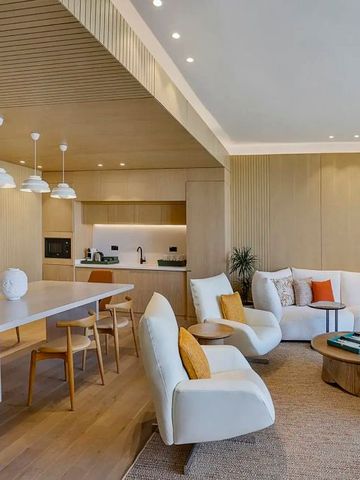 Geräumiges Wohnzimmer mit moderner Küche im Hintergrund