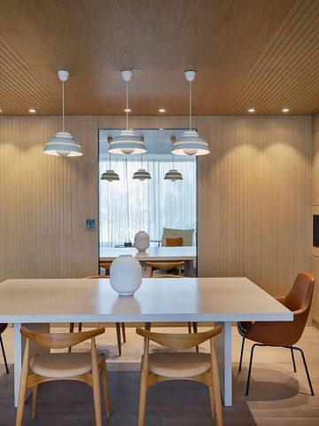 Essbereich mit hellen Holzakzenten und Designleuchten
