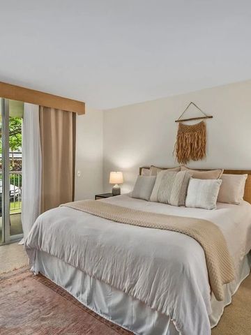 Zimmer mit Kingsize-Bett und neutralen Farben, Fenster mit Blick auf Bäume.