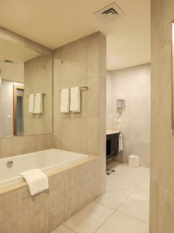 Luxuriöses Badezimmer im Kempinski Al Othman Hotel mit großer Badewanne.