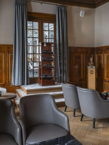 Gemütliche Lounge mit holzvertäfelten Wänden und eleganten Sitzmöbeln