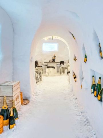 Kühler Iglu-Weinkeller mit Champagnerflaschen und moderner Beleuchtung