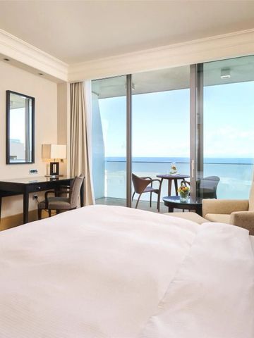 Helles Hotelzimmer mit Balkon und weitem Meerblick