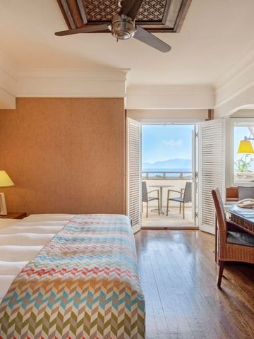 Geräumiges Hotelzimmer mit modernen Möbeln und Meerblick vom Balkon