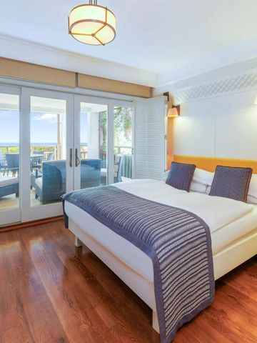 Modernes Gästezimmer mit Balkonzugang und malerischem Meerblick