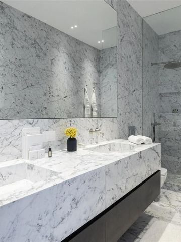 Schickes Bad mit Marmorverkleidung und Doppelwaschbecken