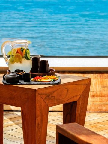 Holztisch mit Obstwasser und Snack vor Meerblick