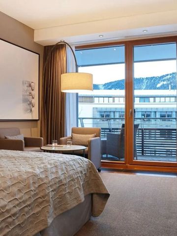 Hochwertig eingerichtetes Hotelzimmer mit Balkon und Bergblick.