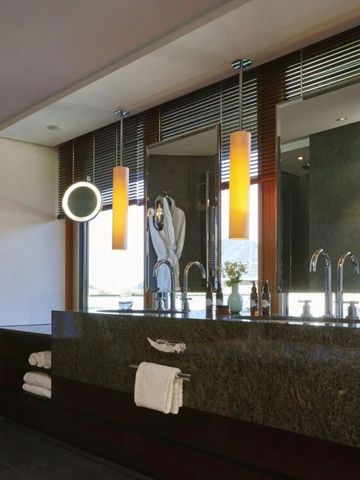 Modernes Badezimmer mit großen Spiegeln und eleganter Beleuchtung