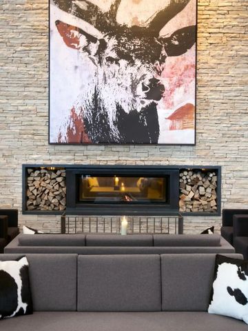 Moderne Lounge mit Kamin und kunstvoller Hirschdekoration an der Wand