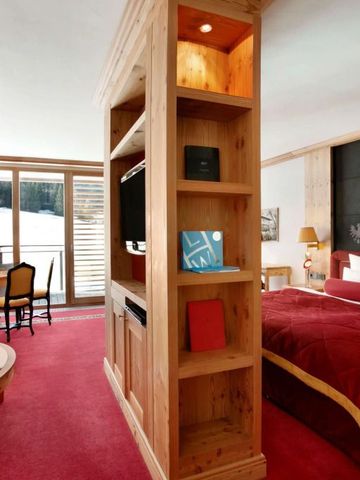 Großzügiges Zimmer mit Holzverkleidungen und Balkon mit Bergblick