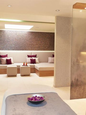 Eleganter Spa-Raum mit bequemen Sitzmöglichkeiten und gemütlicher Beleuchtung.