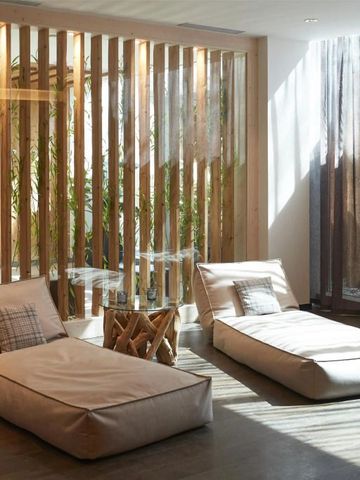 Ruhebereich mit modernen Liegen und natürlichem Licht durch große Fenster.