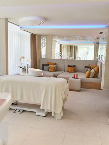 Geräumiger Spa-Bereich mit Massagetisch und großen Fenstern für natürliches Licht.