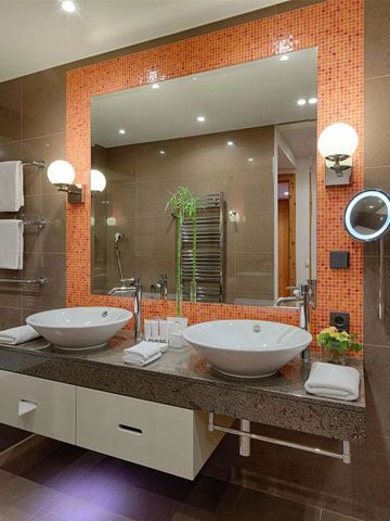 Elegantes Badezimmer mit zwei Waschbecken und großem Spiegel im Kempinski Hotel Das Tirol