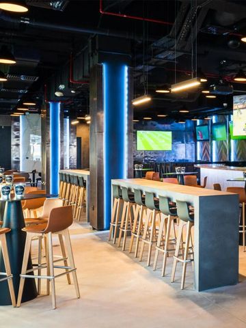 Moderne Bar mit eleganten Sitzgelegenheiten und leuchtenden Lichtelementen.