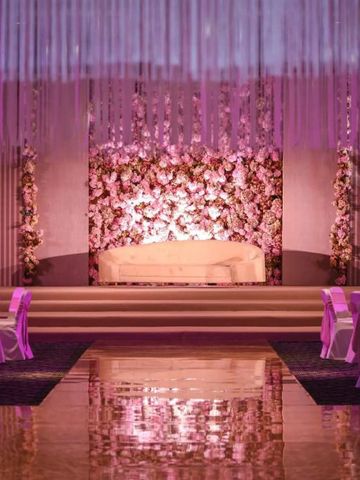 Elegant dekorierte Veranstaltungsfläche mit Blumen und lila Beleuchtung