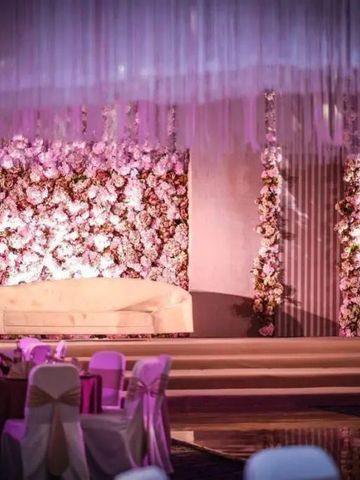 Veranstaltungsraum mit blumengeschmückter Bühne und festlicher Atmosphäre