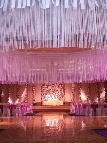 Elegante Veranstaltungseinrichtung mit hängenden weißen Bändern und floraler Dekoration