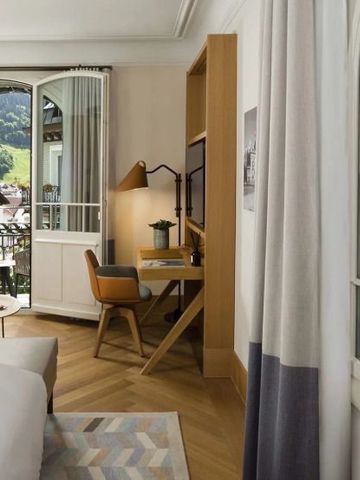 Zimmer mit Schreibtisch und Balkon mit Bergblick