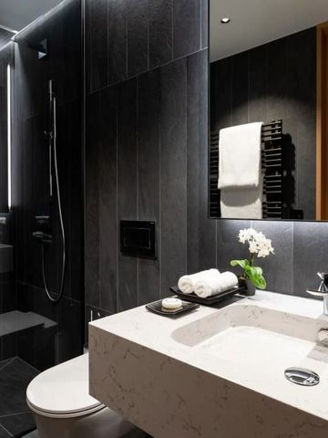 Badezimmer mit eleganter Beleuchtung und Duschkabine