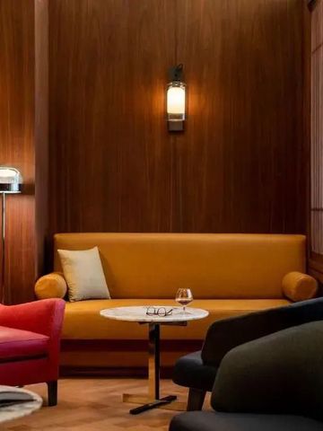 Gemütliche Lounge mit farbigen Sesseln und Holzwänden