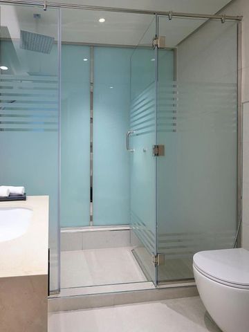Modernes Badezimmer mit Glasdusche und eleganter Armatur.