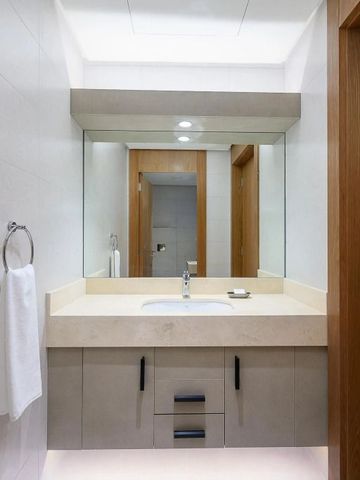 Badezimmer mit großem Spiegel und Waschtisch mit eleganter Ausstattung.