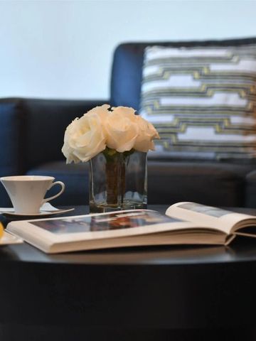 Stilvoller Wohnbereich mit Blumen und Büchern auf dem Tisch