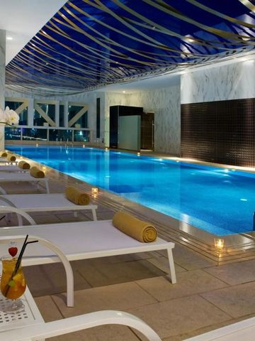 Eleganter Innenpool mit Liegestühlen und Pflanzen.