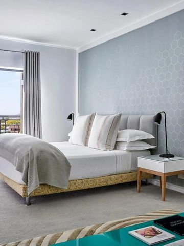 Helles Schlafzimmer mit modernem Design und Meerblick vom Balkon.