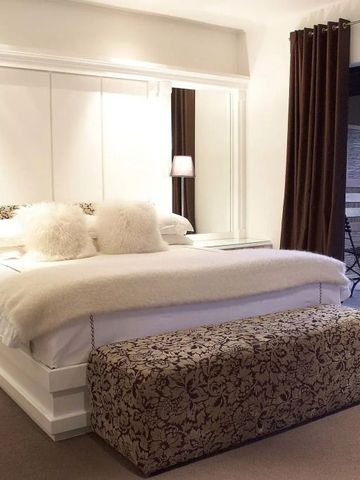 Gemütliches Schlafzimmer mit gepolstertem Bett und Balkonzugang.