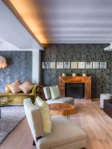 Stylishe Lounge mit Kamin und gemütlichen Sesseln im Hotel.