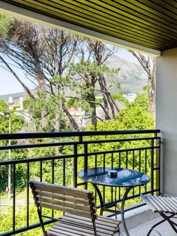 Balkon mit Blick auf grüne Landschaft und Berge im Hintergrund