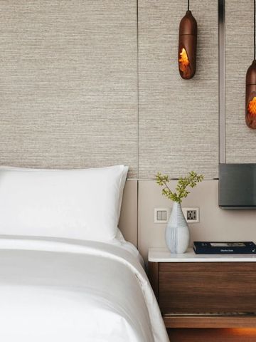 Hotelbett mit eleganten Nachttischlampen und modernem Nachttisch