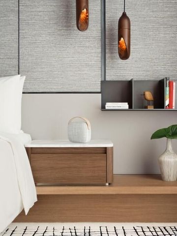 Dekorativer Nachttischbereich mit Kunstpflanze im Hotelzimmer