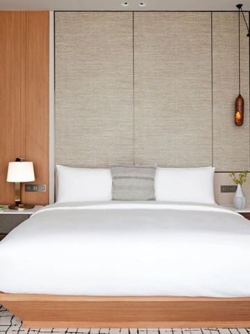 Modern eingerichtetes Hotelzimmer mit edlem Doppelbett und stilvollen Leuchten.