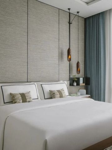 Geräumiges Hotelzimmer mit luxuriösem Kingsize-Bett und sanfter Beleuchtung.