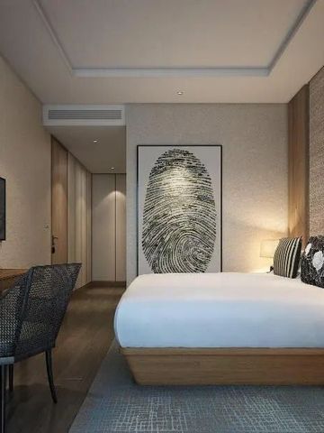 Chic eingerichtetes Hotelzimmer mit Schreibtisch und moderner Kunst an der Wand.