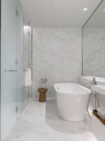 Luxuriöses Badezimmer mit freistehender Badewanne und großer Glasdusche