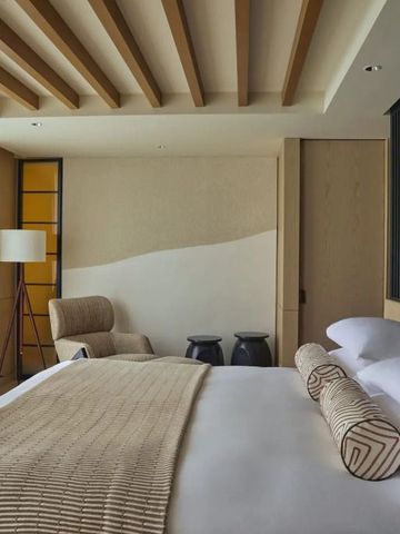 Geräumiges Hotelzimmer mit minimalistischer Einrichtung und stilvollen Akzenten.