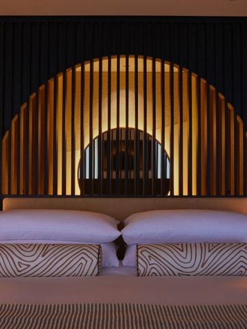 Luxuriöses Hotelzimmer mit dekorativem Kopfteil und gedämpfter Beleuchtung