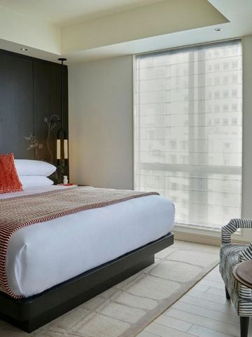 Helles Hotelzimmer mit großem Bett, Fenster und modernem Dekor