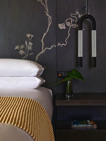 Detailaufnahme eines stilvollen Bettes mit dekorativer Wandkunst